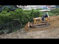 Start new project! Komatsu dozer push stone on old road build foundation with dump trucks unload