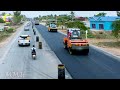 Amazing view of a busy road construction featuring a large asphalt paver, dump truck at work