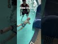 Baby Cooper completes the slide challenge during infant aquatics class